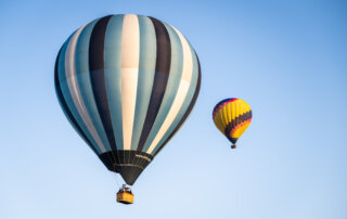 Two hot air balloons just after taking off from a field in Southern California
