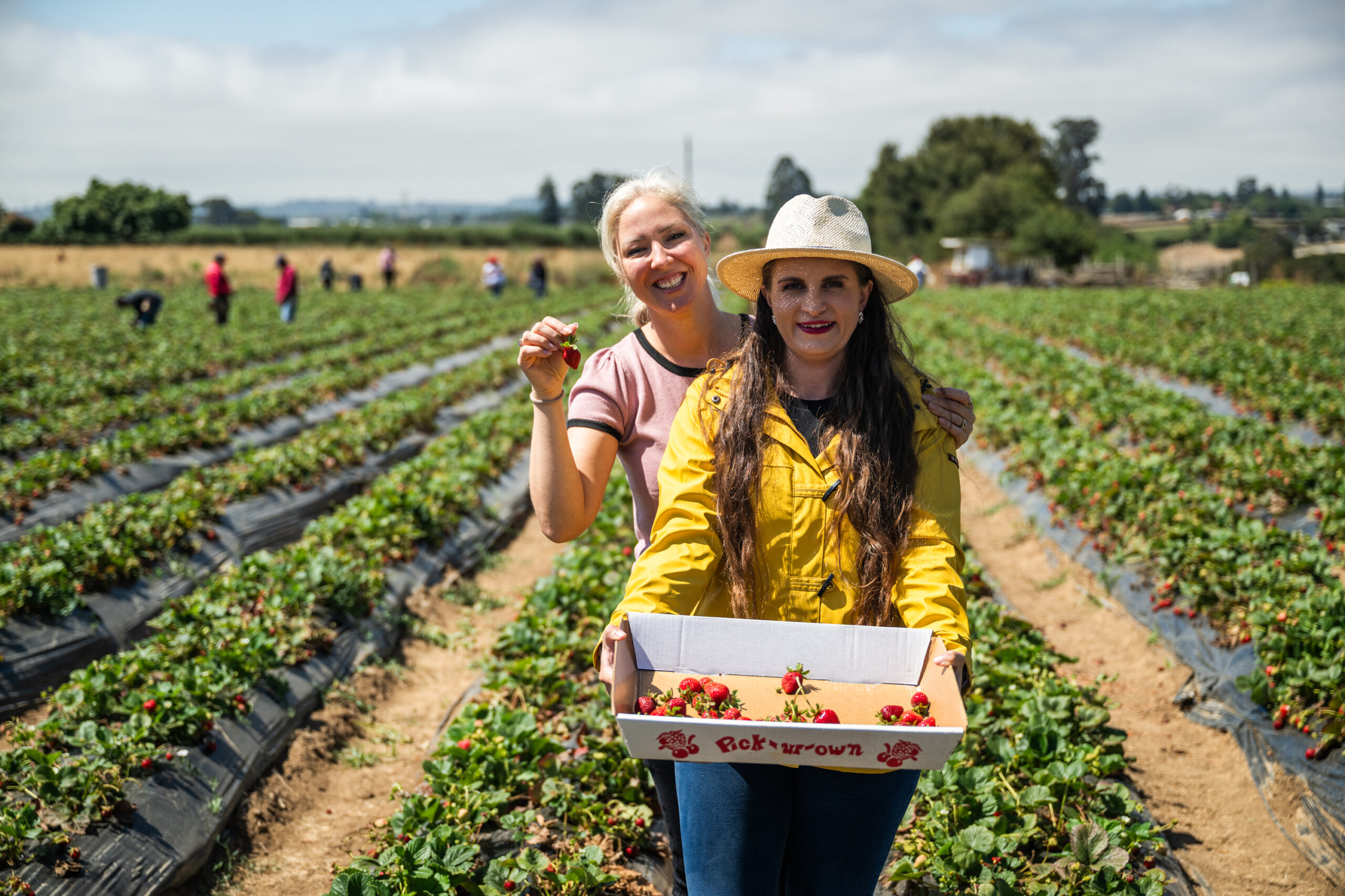 Two delegates pose in the strawberry field