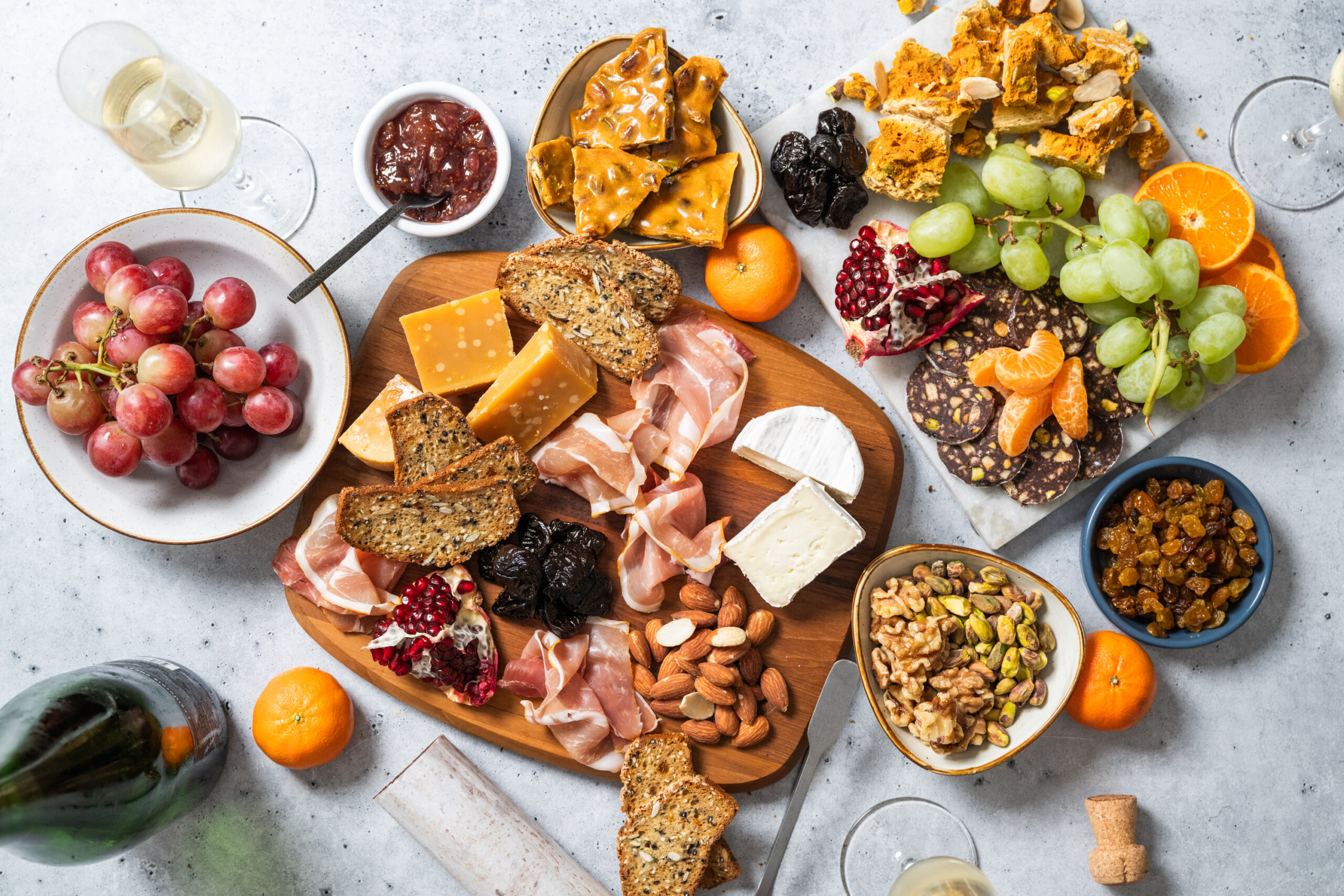 Overhead view of a cheese and charcuterie spread featuring California-grown fruits and nuts