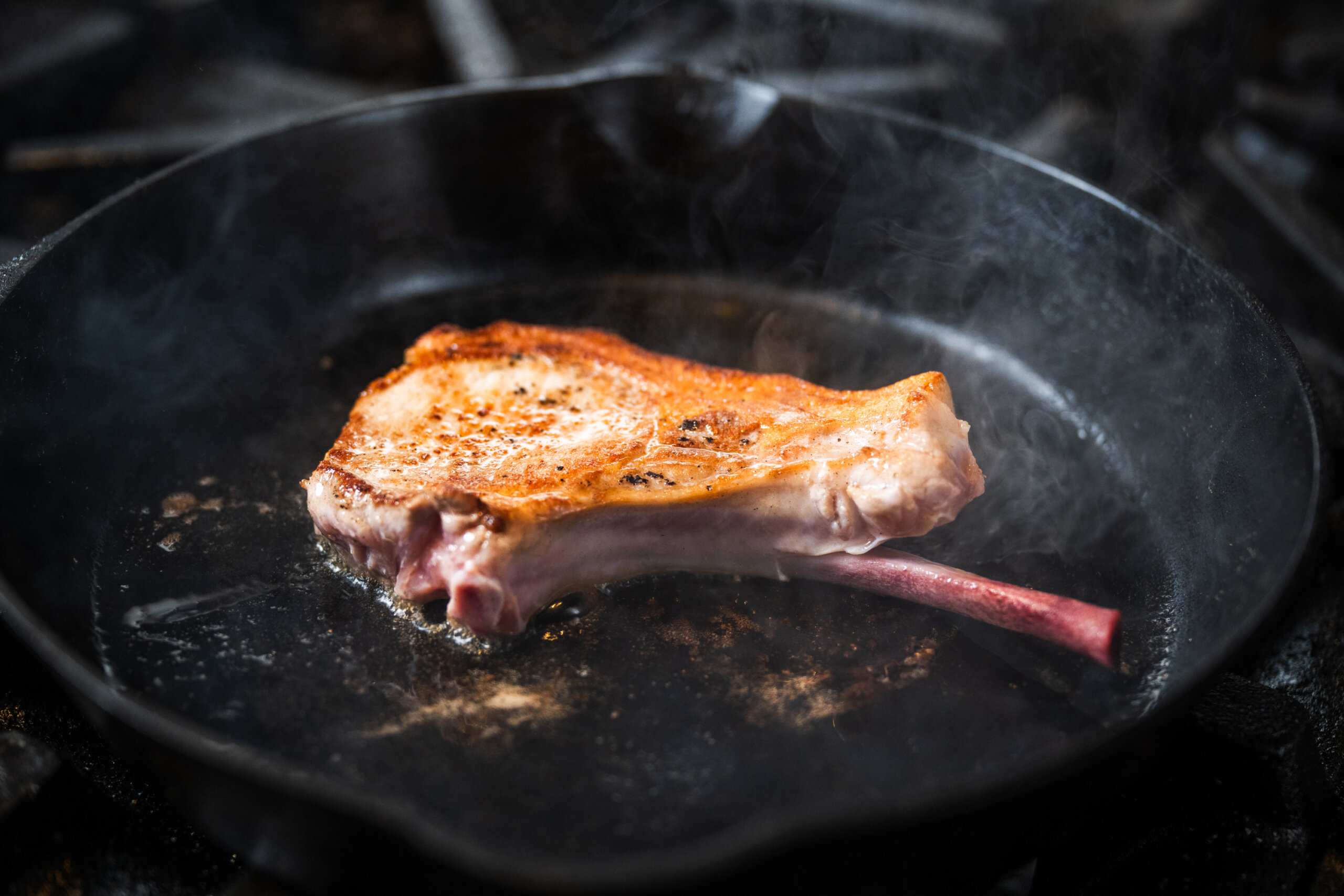 The bone-in chop is first seared in a hot skillet