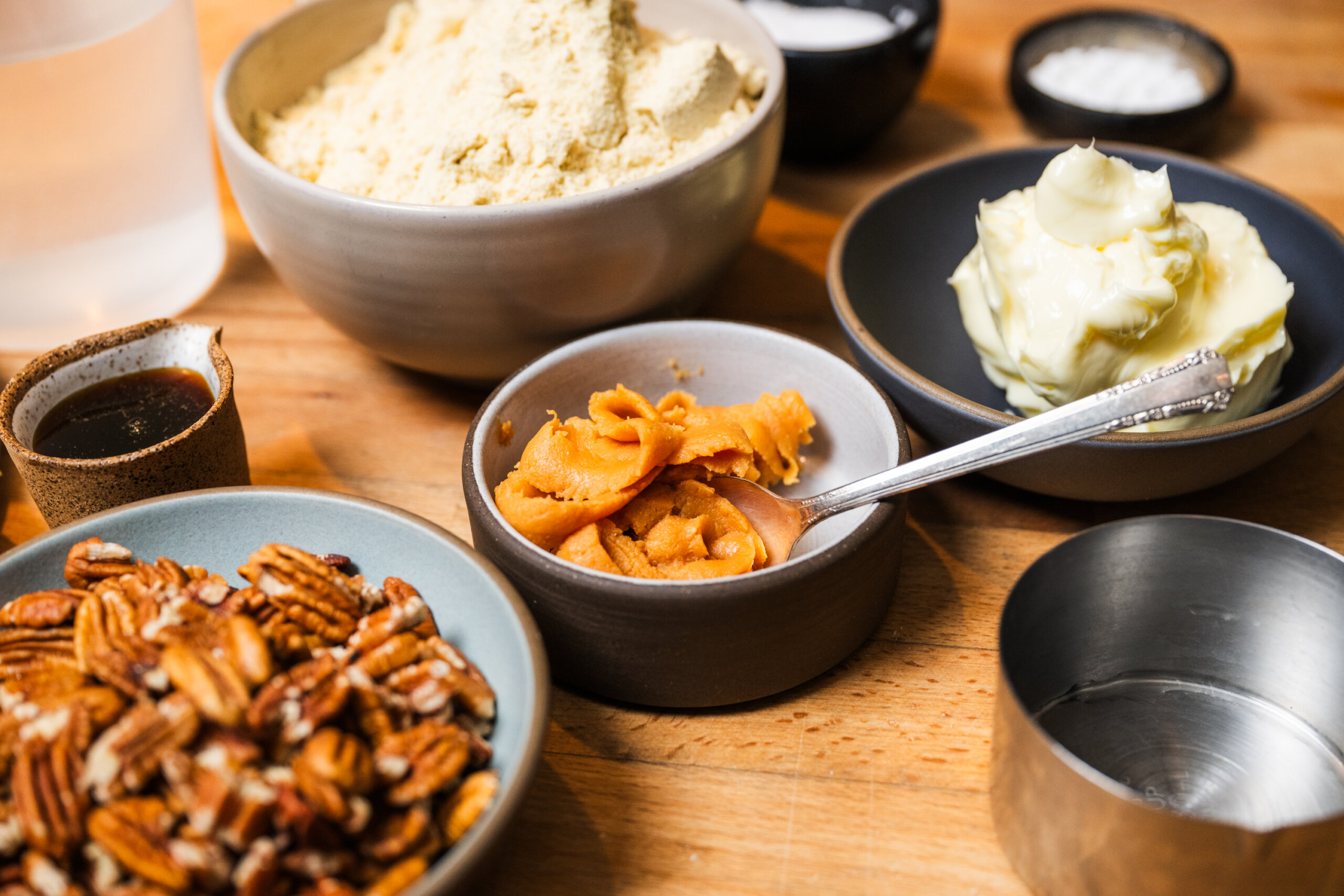 A table with bowls of miso, butter, and pecans.