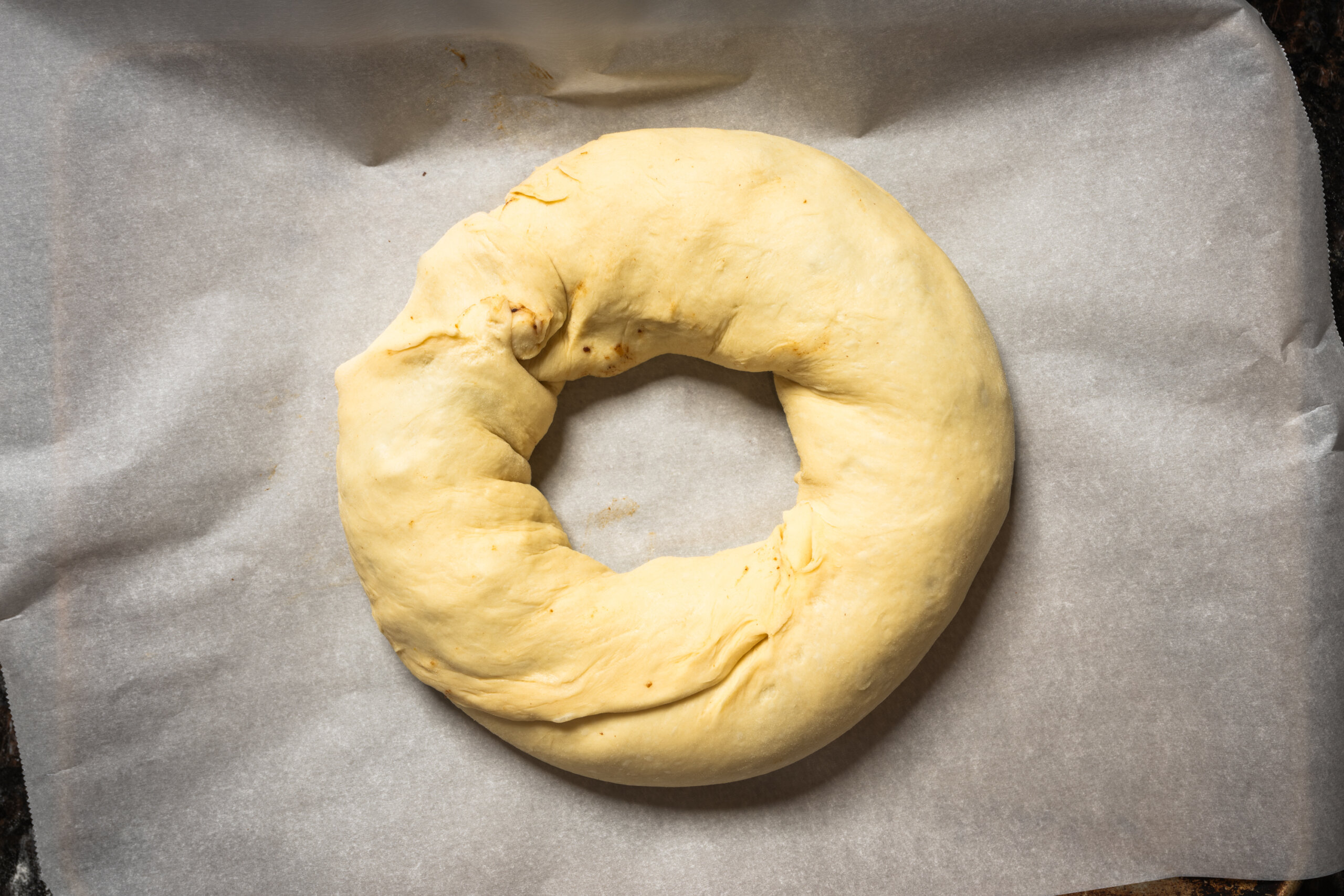 The filled king cake dough is rolled like a cinnamon roll and shaped in a large circle