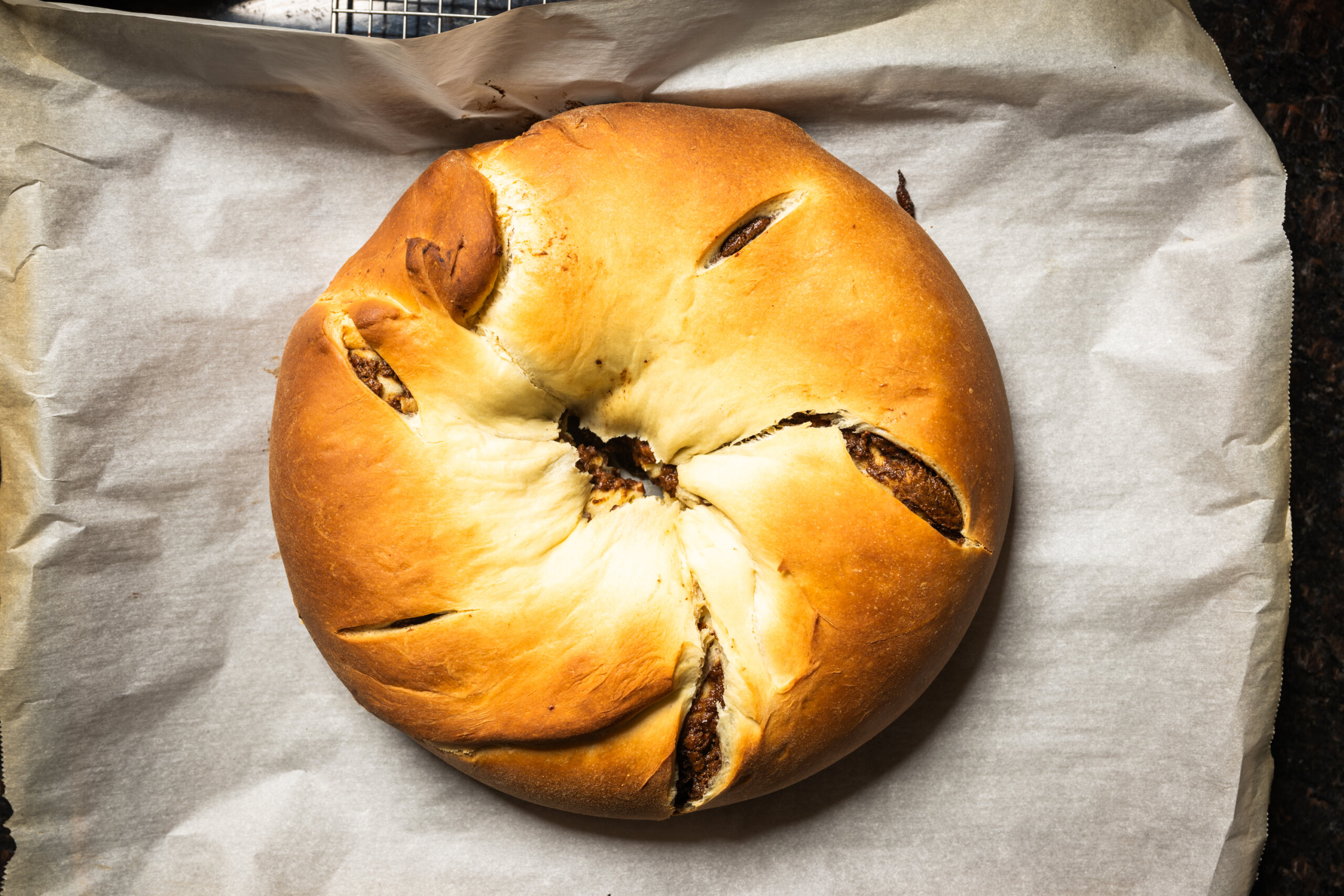 A baked king cake fresh out of the oven, ready for frosting