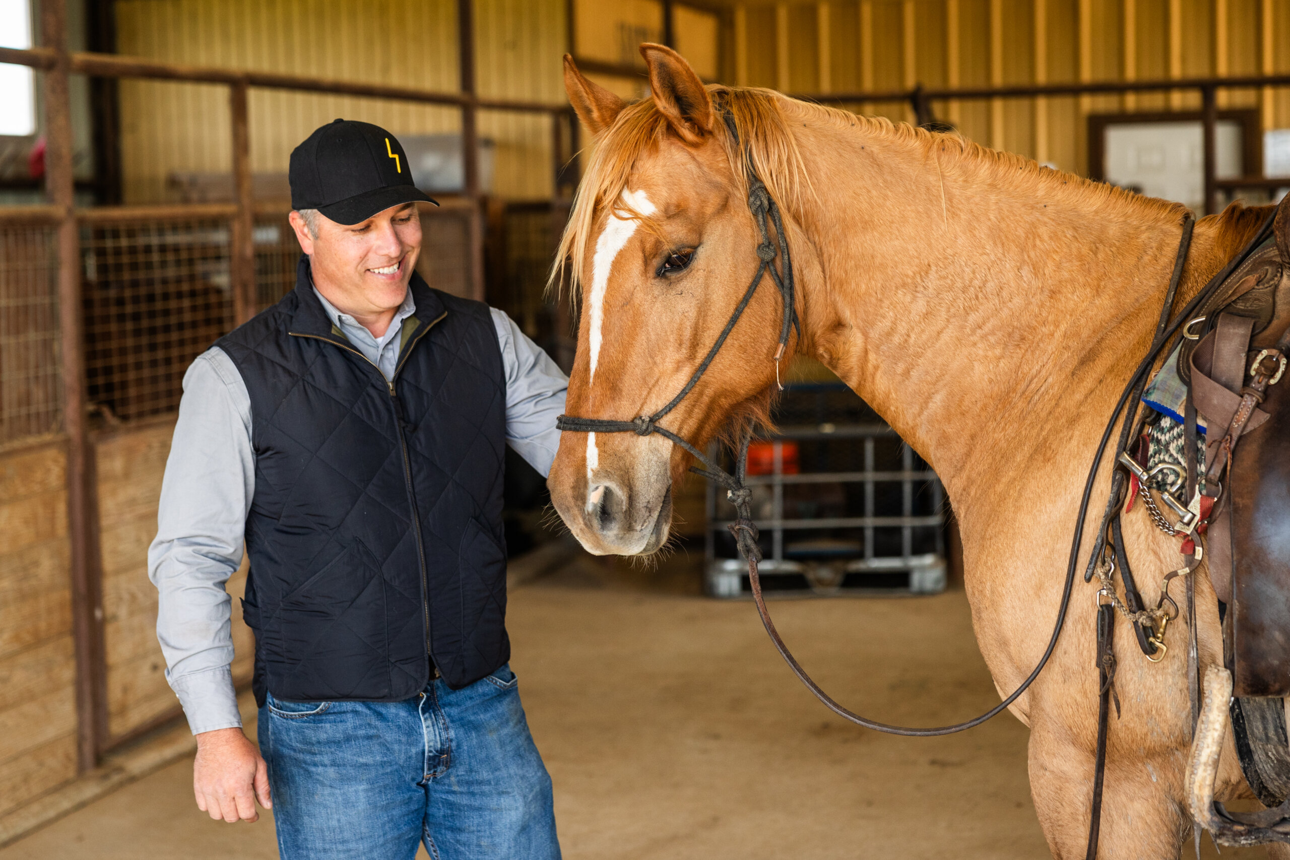 A portrait of Lance Roasa with one of the horses of Santa Rosa Ranch