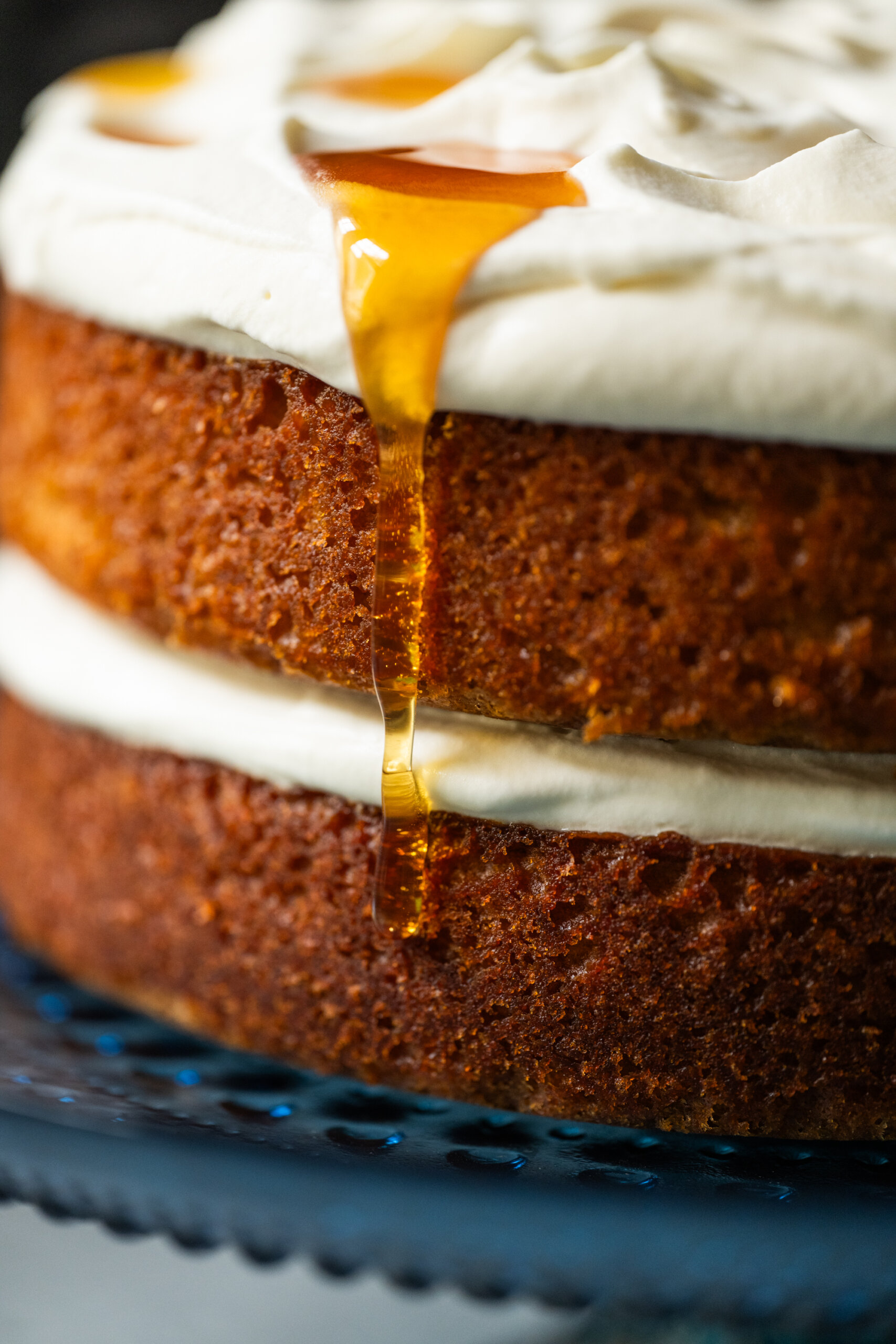A drizzle of pure honey runs down the side of the finished cake