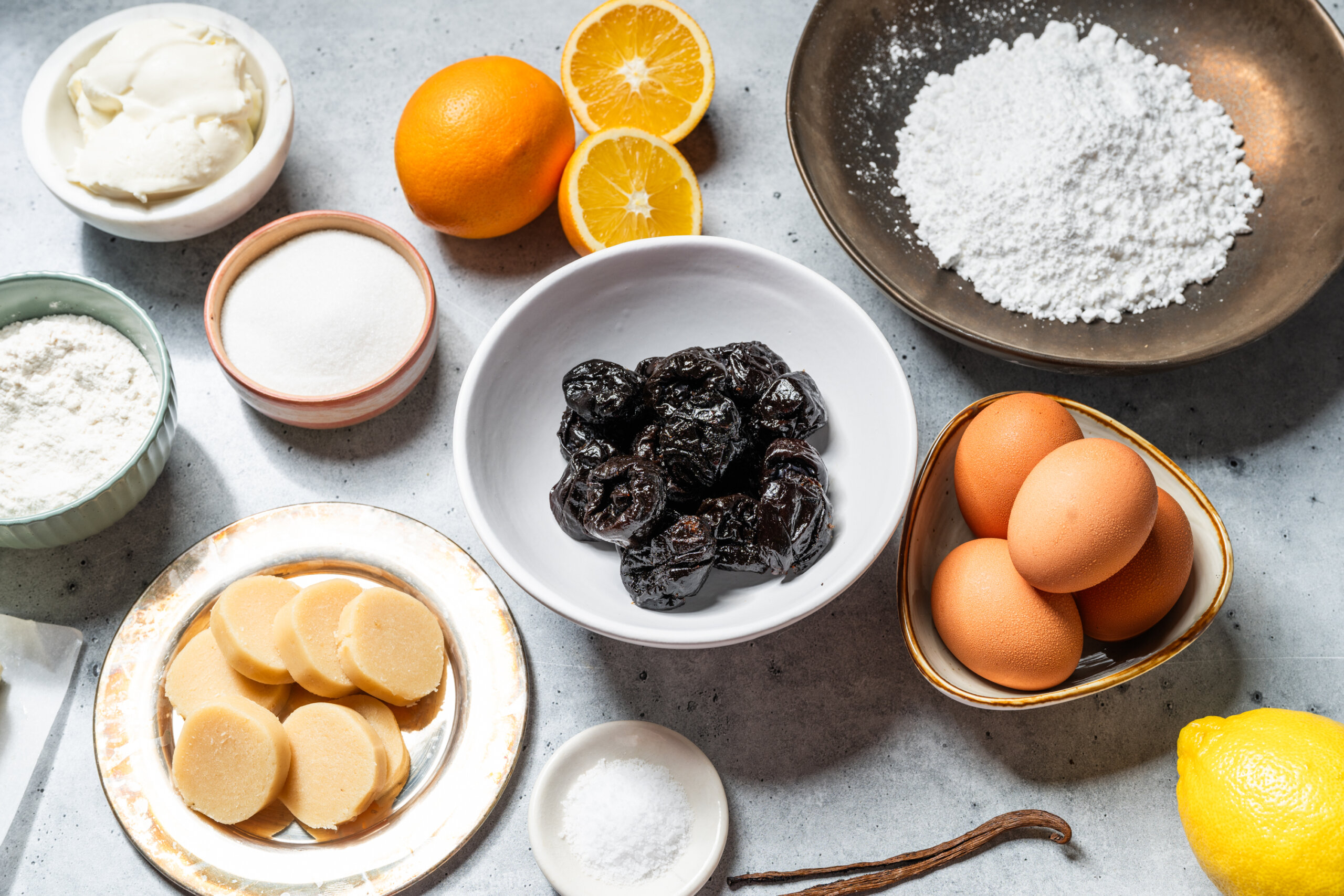 Ingredients prepped for the prune cake - almond paste, vanilla, eggs, flour, powdered sugar, and pitted California prunes