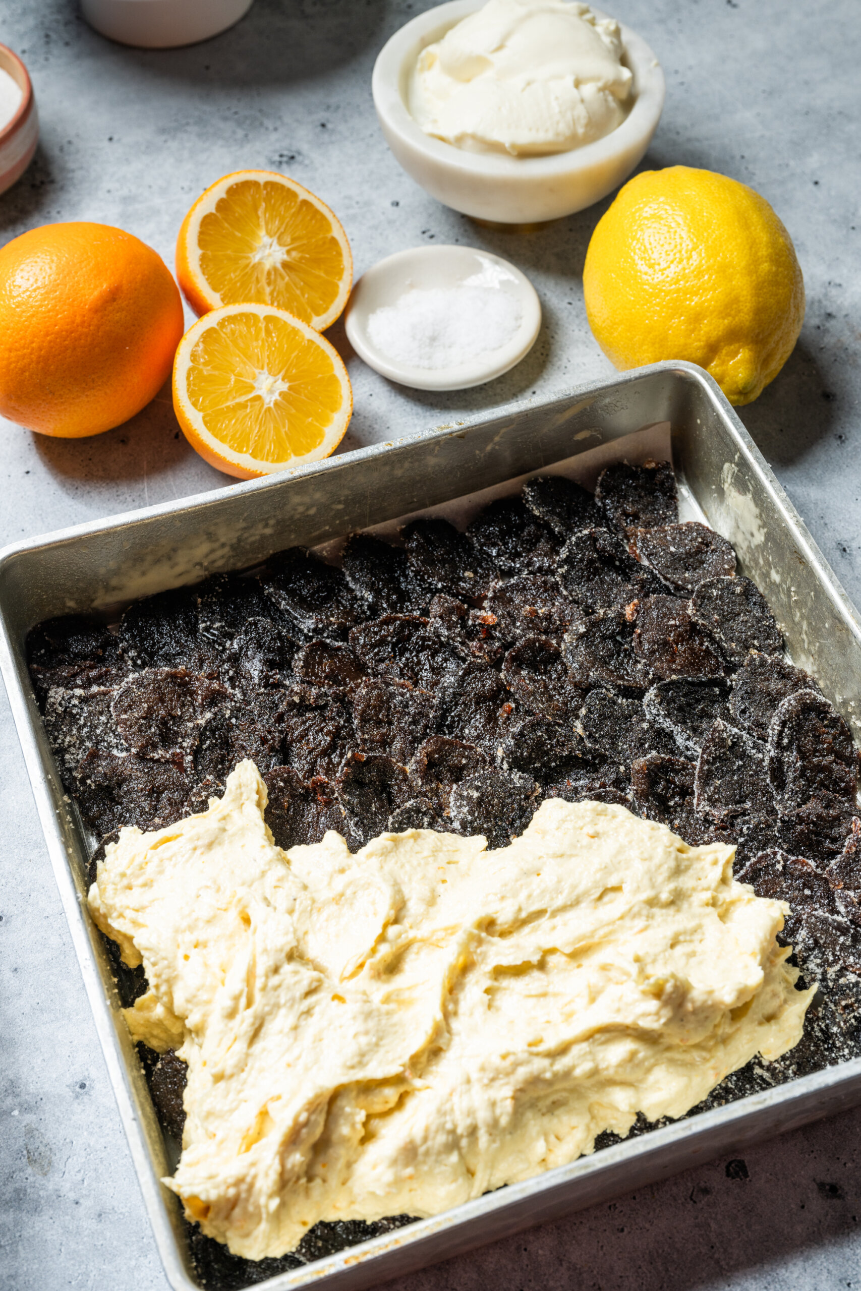 Batter for the cake is spread out over the shingled prunes