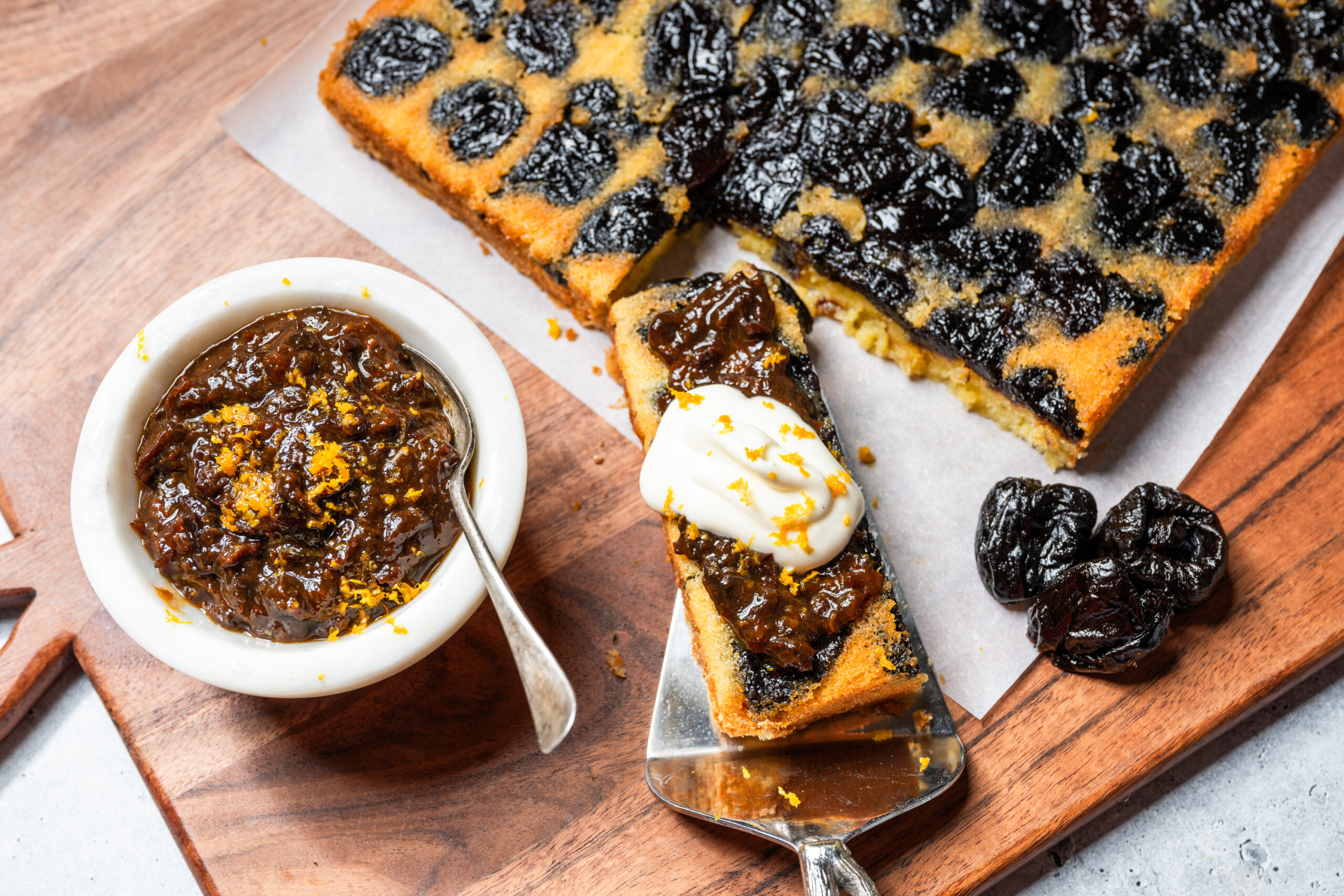 A slice of the finished cake, with a spoonful of prune-orange gastrique and a dollop of chantilly cream