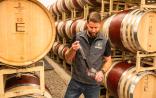 Winemaker Keith Hammond uses a wine thief to take samples in the Emeritus barrel room