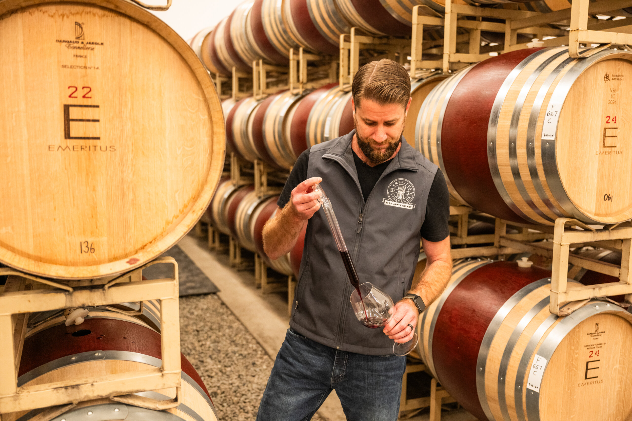 Winemaker Keith Hammond uses a wine thief to take samples in the Emeritus barrel room