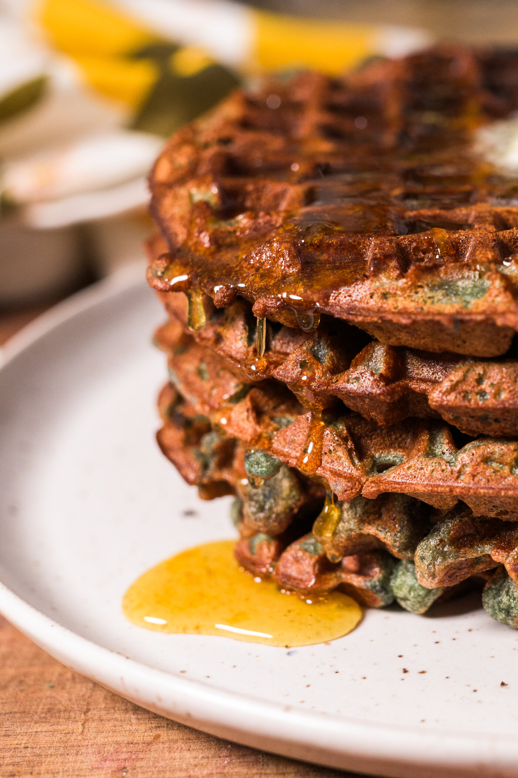 Honey syrup drips down the side of a stack of sweet potato pancakes.