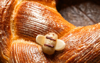 A marzipan bee decorates a king cake made from laminated dough