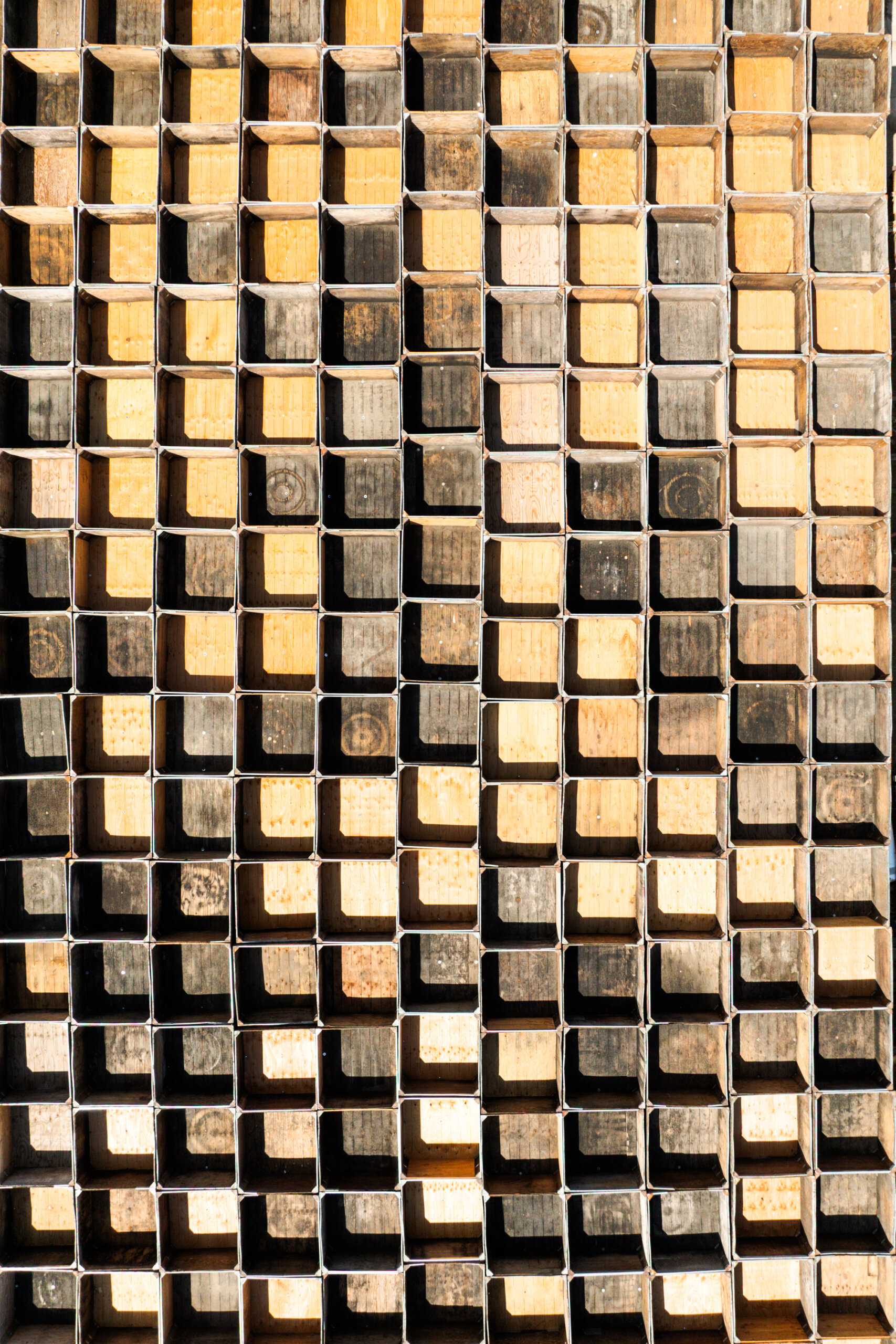 Stacked rectangular metal tubes filled with wooden blocks arranged vertically, creating a repetitive geometric pattern.